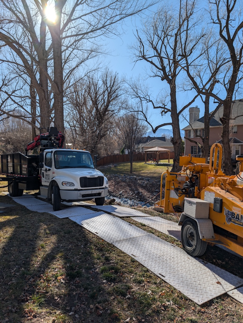 Branded trucks on ground protection mats at creek job