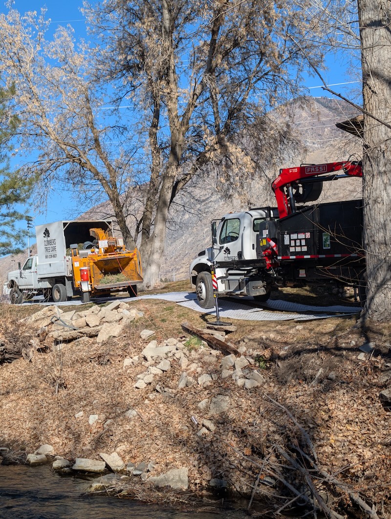 Two Climbers Tree Care trucks at creek job site